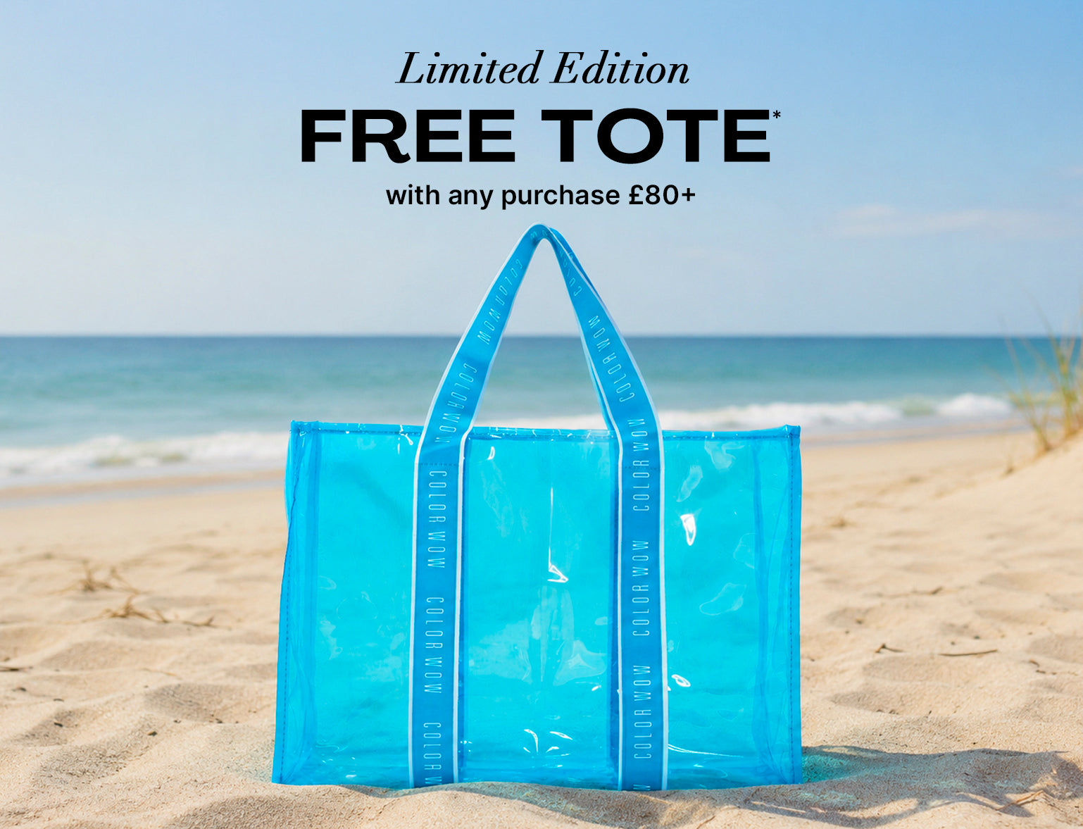 Color Wow Limited Edition Free Tote promotional banner. Offer: Get a free blue beach tote with any purchase of 80 pounds or more. Visual features the transparent blue tote sitting on a sandy beach by the ocean.
